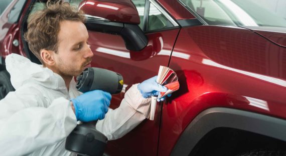 Professional auto painter matches car paint color with lamp and samples